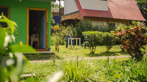 a green house with a table and chairs in a yard at Cabañas yami in Playa Ladrilleros