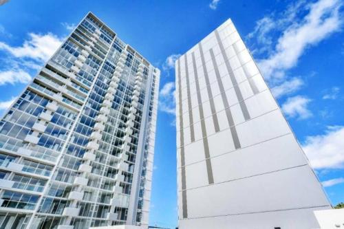 un edificio blanco junto a un edificio alto en 0509 iFreses Hermoso Apartamento con Aire Acondicionado y Parqueo, en Curridabat