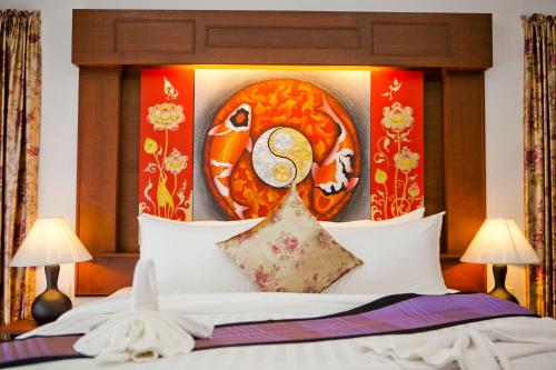 Una cama con una cabecera con una pintura. en Chongfah Mountain View en Khao Lak