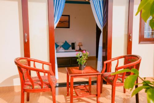 a room with two chairs and a table and a bed at Tra Que Green Villa Hoi An in Hoi An