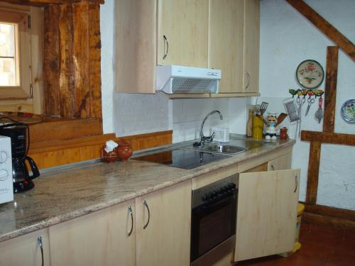 a kitchen with a sink and a stove at Casa Artio in Ansó