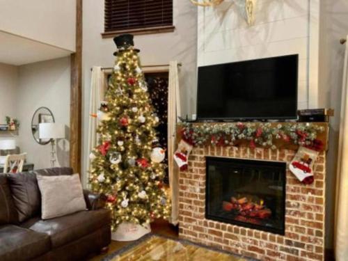 a christmas tree in a living room with a fireplace at SPACIOUS FAMiLY HOME in Hollister