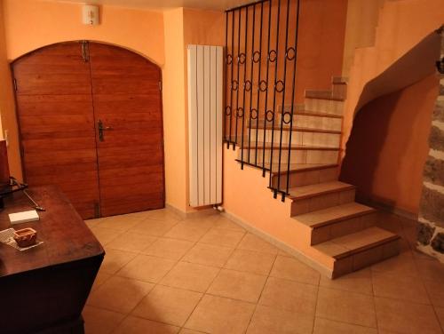 een hal met een trap in een huis met een deur bij Mas de la fontaine in Lafarre