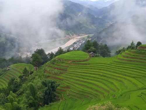 a view of a valley with rice terraces on a mountain at Homestay Ngọc Thủy Điểm dừng chân lên Đồi Mâm Xôi in Mù Cang Chải