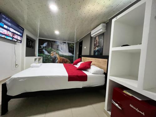 ラ・ドラダにあるHotel Entre Parquesのベッドルーム1室(猫が座るベッド1台付)