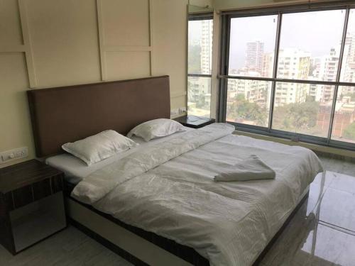 a large bed in a room with large windows at Ocean View Luxury Designer condo in Mumbai