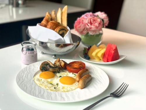 a table with two plates of food with eggs and bread at The Olympian Hong Kong in Hong Kong