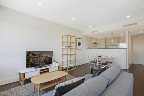 - un salon avec un canapé et une table dans l'établissement The Prince Lakefront Kingston ACT, à Canberra
