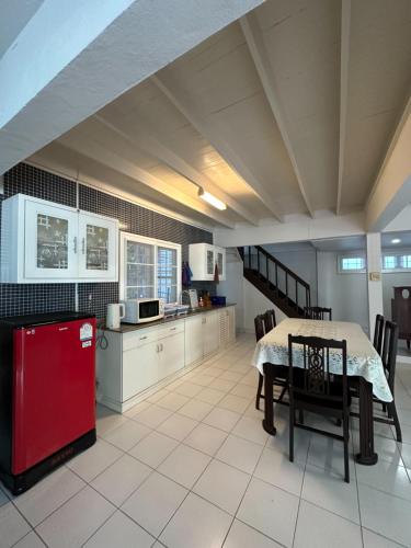 a kitchen with a table and a red refrigerator at Journey House Bangsean in Ban Laem Thaen