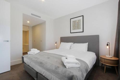 a bedroom with a large bed with towels on it at The Prince 228 Kingston ACT in Canberra