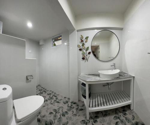 a white bathroom with a sink and a mirror at Journey House Bangsean in Ban Laem Thaen