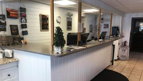 a lobby with a counter with a mirror at Colonial Inn Ellsworth in Ellsworth