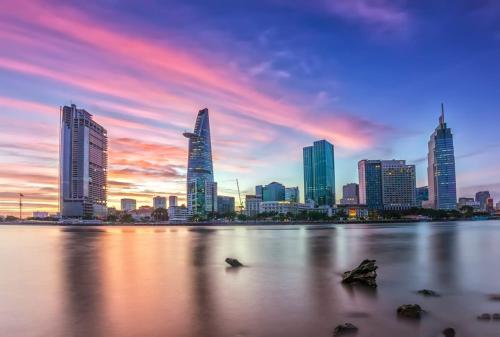 a city skyline at sunset with buildings in the water at Thinh Gia Phat Hotel Hoang Hoa Tham in Ho Chi Minh City