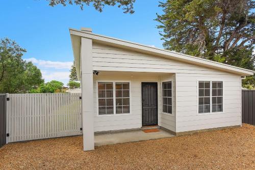 a white garage with a door and a fence at 24A Petrel Ave - Wi-Fi - No Linen Included in Encounter Bay