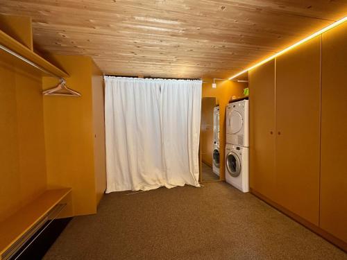 a laundry room with a white curtain and a washing machine at Le Nid - Versegere near Verbier - 4 Valleys in Versegeres 