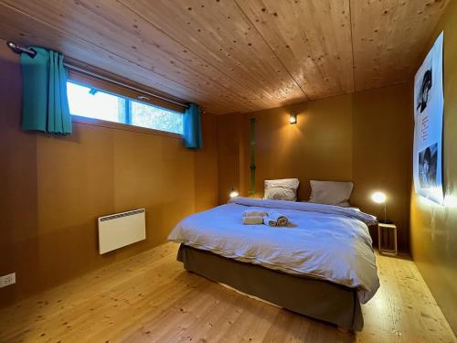 a bedroom with a large bed and a window at Le Nid - Versegere near Verbier - 4 Valleys in Versegeres 