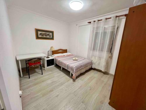 1 dormitorio con cama, escritorio y ventana en ZARAGOZA CENTRAL APARTMENT, en Zaragoza