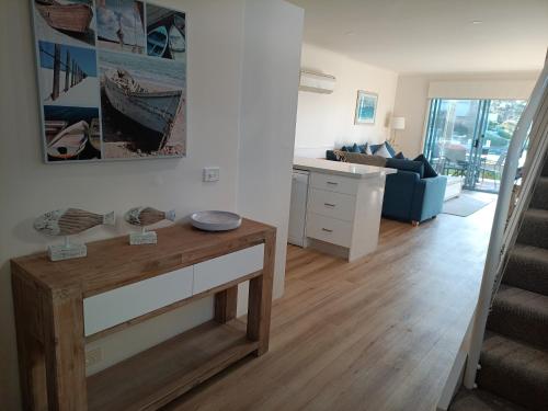 a living room with a table and a blue couch at Captains Cove Resort - Waterfront Apartments in Paynesville