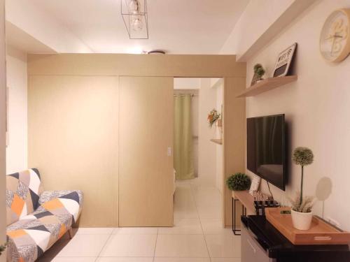 een woonkamer met een bank en een flatscreen-tv bij Wind Residence T4- I Near TAAL VIEW at sky lounge in Nasugbu