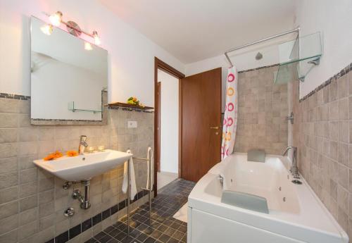uma casa de banho com um lavatório, uma banheira e um WC. em Villa Aquila em Pianello Del Lario