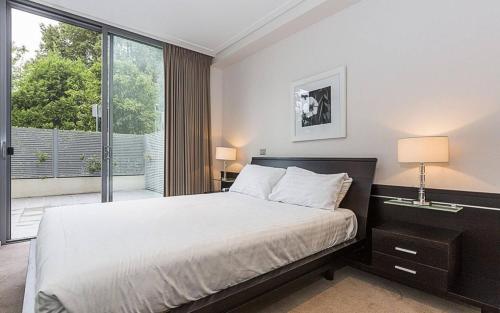 a bedroom with a bed and a large window at Glebe Park Canberra City ACT in Canberra