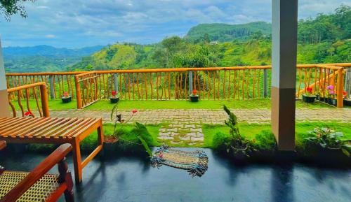 a balcony with a view of a garden and mountains at Rainbow Sky Cottage in Ella
