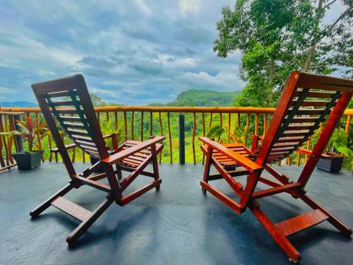 two rocking chairs sitting on a porch with a view at Rainbow Sky Cottage in Ella