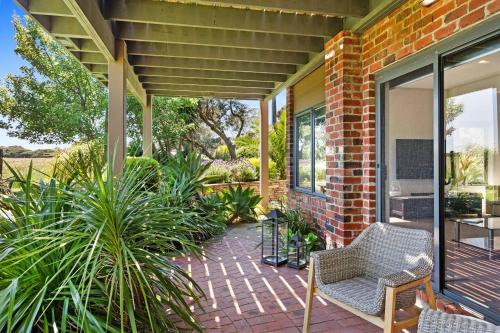 a patio with chairs and plants on a house at Coastal meets Country at this Ventnor Beach Escape in Ventnor