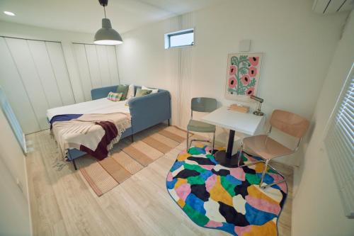 een slaapkamer met een bed, een tafel en een stoel bij Orange County in Shinjuku in Tokyo