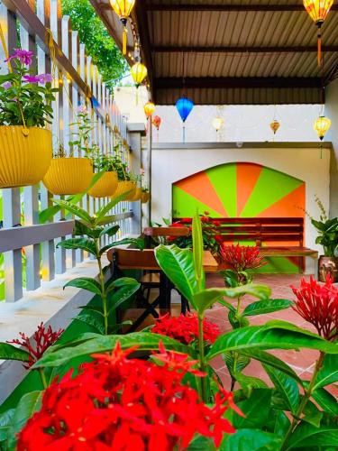 un patio con panchina e fiori e piante rossi di Lion homestay a Ða Gia