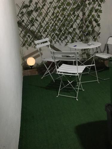 a couple of chairs and a table with green grass at Da Julia in Oristano