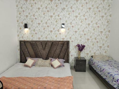 een slaapkamer met 2 bedden en een muur met bloemen bij Varanasi homestay in Varanasi