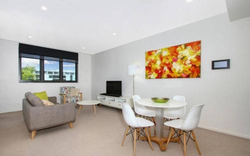 a living room with a couch and a table and chairs at IQ Smart Apartments 507 Braddon ACT in Canberra