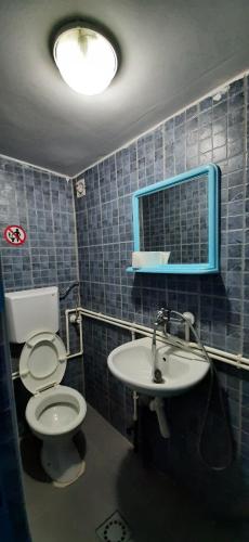 a bathroom with a toilet and a sink and a mirror at City Rooms 400m from Center in Mitrovicë
