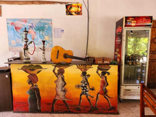 a kitchen with a painting on the side of a refrigerator at Mkeka Spice Lodge Jambiani in Jambiani