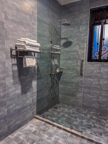 a shower with a glass shower stall in a bathroom at Bellwether Apartments in Kampala