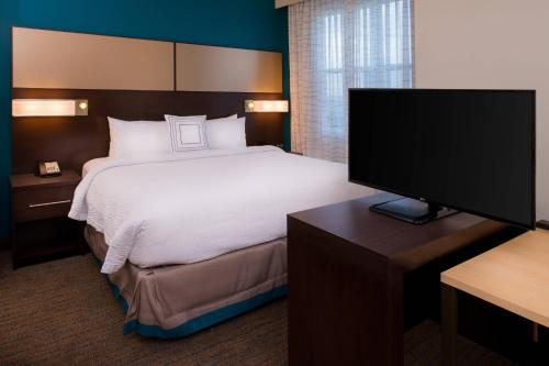 a hotel room with a bed and a flat screen tv at Residence Inn by Marriott Miami West/FL Turnpike in Miami