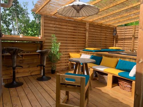 un patio esterno con tavolo, sedie e ombrellone di Maisonnette atypique cadarache-iter a Saint-Paul-lès-Durance