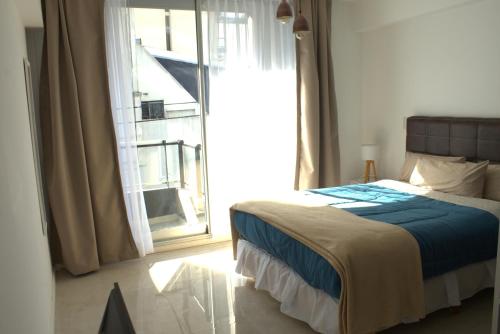 1 dormitorio con cama y ventana grande en Moderno Ambiente a Estrenar en San Telmo, cerca del Obelisco 21 en Buenos Aires