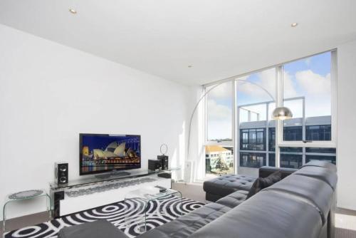 a living room with a couch and a flat screen tv at Realm 12 in Canberra