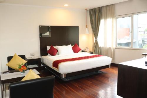 a bedroom with a large bed with red pillows at 37th Crescent Hotel Bengaluru in Bengaluru
