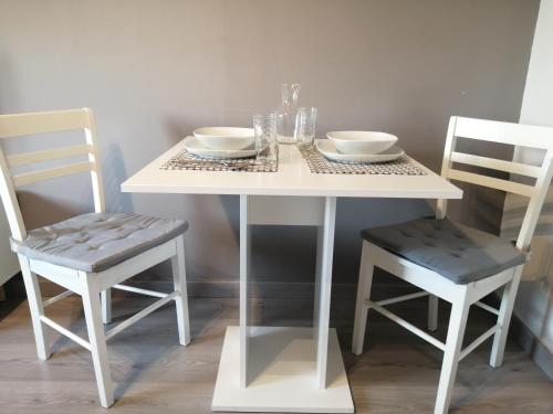 ベテューヌにあるNuit étoiléeの白いテーブルと椅子2脚(皿、ボウル付)