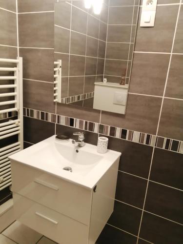 une salle de bain avec un lavabo blanc et un miroir dans l'établissement Nuit étoilée, à Béthune