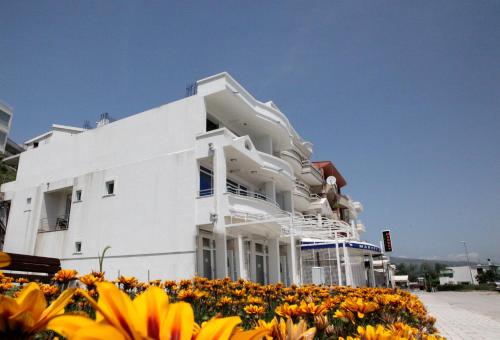 a white building with flowers in front of it at Apartments Art in Ulcinj