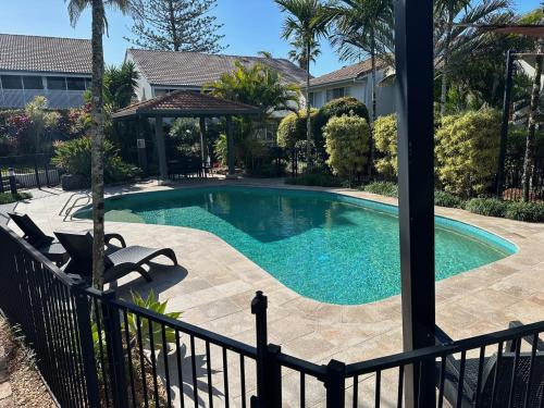 a swimming pool in a yard next to a house at Secret Gem in Peregian Beach