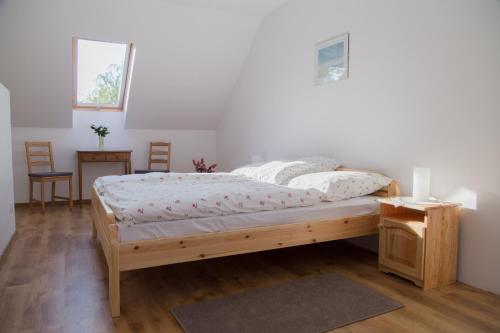 a bedroom with a bed and a table and chairs at Almafás Jakuzzis Apartmanház Őrség in Kerkakutas