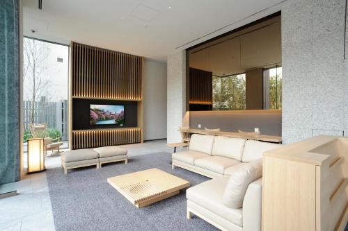 a living room with a couch and a tv at Hotel Keihan Tsukiji Ginza Grande in Tokyo