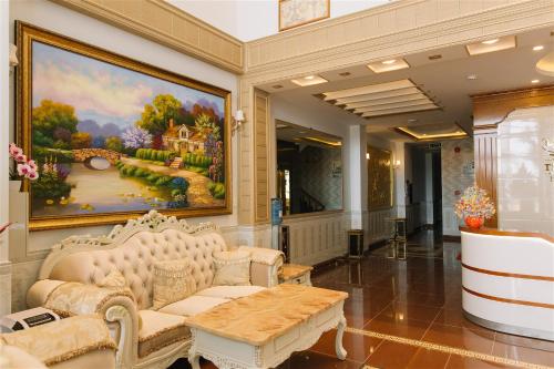 - un salon avec un canapé et un tableau mural dans l'établissement Thinh Gia Phat Hotel Hoang Hoa Tham, à Hô-Chi-Minh-Ville