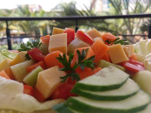 a pile of cheese and vegetables on a plate at Shangri-la Hotel Muyenga in Bugolobi