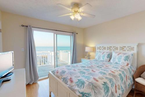 a bedroom with a bed with a view of the ocean at System Shutdown in Kure Beach